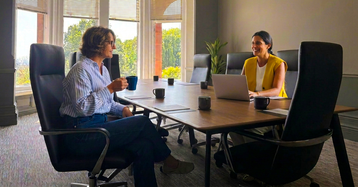 Two colleagues talking in a meeting room at Robert Denholm House, flexible office space in Nutfield, Surrey
